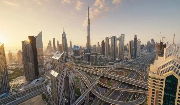 Moderner Bürotisch mit Computer, Notebook und Pflanze auf einem Holztisch.
