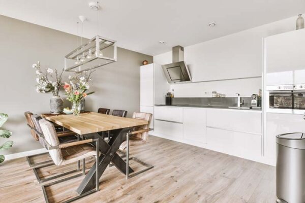 Nahaufnahme einer lächelnden Frau mit schwarzer Gesichtsmaske und rotem Lippenstift, die direkt in die Kamera schaut.