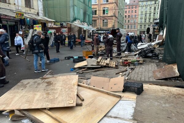 Close-up shot of colorful abstract art painting with shades of blue, green, and yellow swirls.
