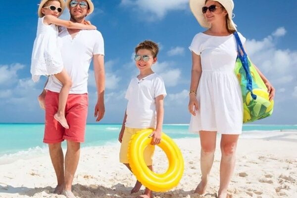 Eine Familie mit zwei Kindern genießt einen sonnigen Strandurlaub im Mai in Russland.
