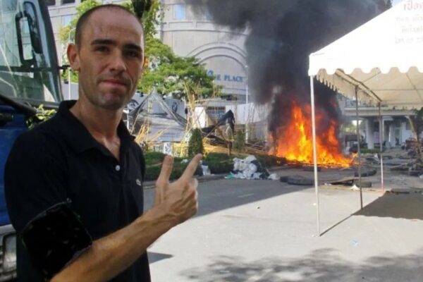 Gruppe von Touristen reiten auf einem Kamel in der Wüste bei Sonnenuntergang, Abenteuer-Reise-Konzept.