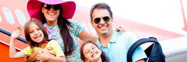 Sleek blue sports car driving on a winding road with mountains in the background.