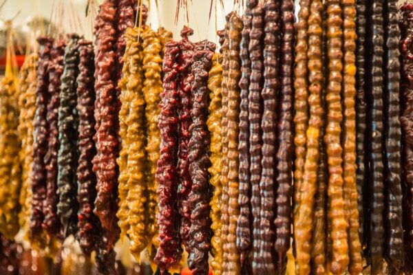 Eine schöne rosa Rose in voller Blüte mit Tautropfen auf den Blütenblättern, isoliert auf einem weißen Hintergrund.