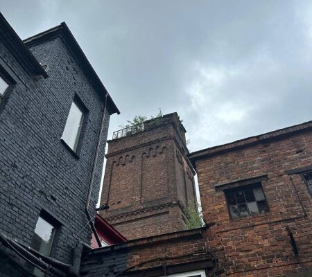 Ein vertikales Bild, das eine Person zeigt, die einen Laptop mit SEO-Tools und Diagrammen auf dem Bildschirm benutzt.