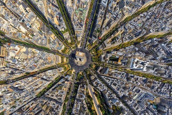 Luftaufnahme einer Stadtlandschaft mit hohen Gebäuden und Straßen aus der Vogelperspektive.